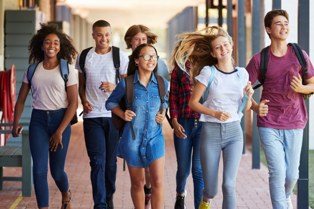 A diverse group of teenagers walking together through a school hallway