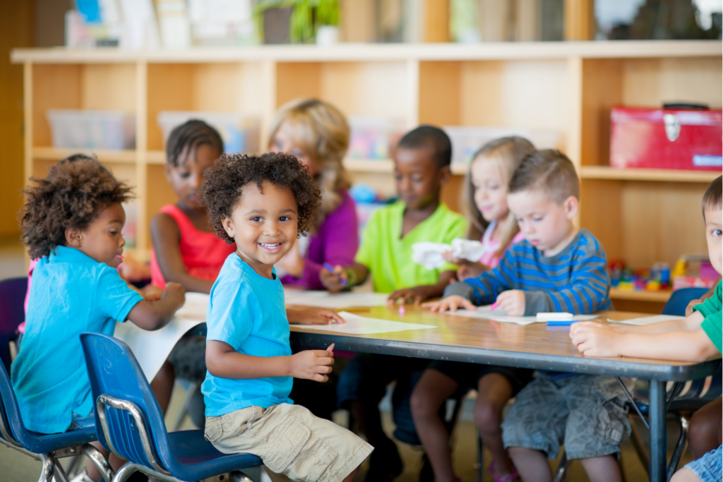 Young children working together at a classroom table on a project