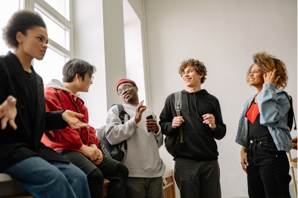 A diverse group of young people in conversation in a school setting